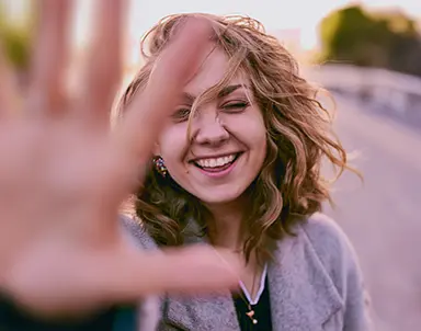 Pacientă zâmbind relaxată după experiența pozitivă la o clinică stomatologică recomandată de platforma RecomandDentist.ro