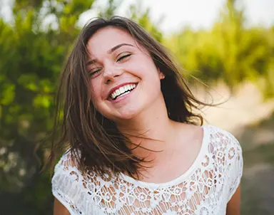 Pacientă zâmbind natural după o experiență pozitivă într-o clinică recomandată prin platforma RecomandDentist.ro